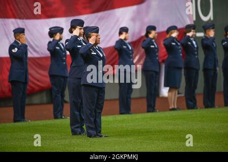 Le colonel Katrina Stephens, commandant de l'installation, et 30 autres aviateurs de la base aérienne de Hanscom, Massachusetts, saluent tandis que l'hymne national est joué avant un match de Boston Red Sox au Fenway Park à Boston le jour du drapeau, en juin. 14. Banque D'Images