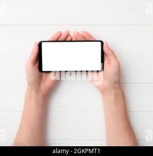 Smartphone noir avec écran blanc entre les mains Banque D'Images