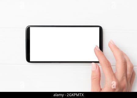 Smartphone noir avec écran blanc entre les mains Banque D'Images