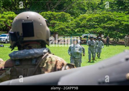Les policiers des forces de police du Costa Rica se rencourent vers un hélicoptère de l'armée américaine UH-60 Blackhawk affecté au 1er Bataillon, 228e Régiment d'aviation, Force opérationnelle interarmées-Bravo, base aérienne de Soto Cano, Honduras, lors de l'entraînement du système d'insertion et d'extraction rapide de corde (FRITES) au Libéria, Costa Rica, le 15 juin 2021. L'objectif de cet exercice était d'améliorer l'interopérabilité avec les pays partenaires, d'acquérir de l'expérience avec différentes possibilités de formation et de renforcer les relations avec les forces de police du Costa Rica. Banque D'Images