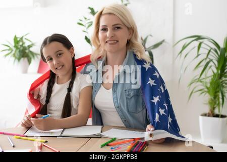 L'aide pour les devoirs est maintenant largement requise parmi les écoliers. Apprendre la langue anglaise aux Etats-Unis. Étudiante anglaise avec le drapeau américain à la Banque D'Images