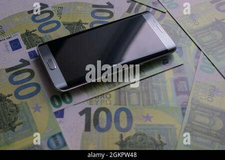 smartphone se trouve sur 100 billets en euros Banque D'Images