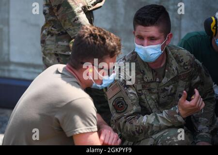 Senior Airman Tyler J. Vance, 31e Escadron de génie civil (ces) compagnon de charpente, à droite, train Airman Bryce E. Schneider, 31e apprenti de charpente de la ces, à propos de l'abri d'avion dur à la base aérienne d'Aviano, en Italie, le 16 juin 2021. Au cours de la formation, l'équipe a remplacé un rouleau de guidage par une porte de tablier. Banque D'Images