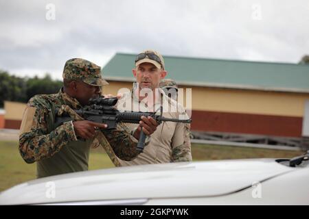 Un agent de la Drug Enforcement Administration (DEA) guide un membre de la Jamaica Defence Force (JDF) sur l'extraction d'un véhicule pendant Tradewinds 2021, Camp Stephenson, Guyana, juin 16. Des agents de l'AEA se sont joints aux soldats américains du 1er Bataillon, 3e détachement opérationnel du Groupe des forces spéciales Alpha (ODA 7-326) et de la 54e Brigade d'assistance de la Force de sécurité (SFAB) à titre de conseillers pour l'exercice. Les troupes de la Force de défense du Guyana et de la Force de défense de la Jamaïque ont reçu une expérience pratique des tactiques nécessaires pour extraire le personnel des véhicules de manière sûre et efficace. Tradewinds 2021 est un Carib parrainé par le Southern Command des États-Unis Banque D'Images