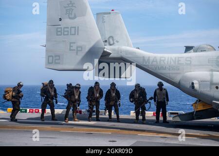 MER DES PHILIPPINES (16 juin 2021) les Marines affectés à la 31e unité expéditionnaire maritime (UMM) se préparent à embarquer un Osprey MV-22B du 31e UMM sur le pont de vol du navire d'assaut amphibie déployé par l'avant USS America (LHA 6). L'Amérique, navire chef de file du America Amphiobie Ready Group, ainsi que le 31e MEU, opère dans la zone d'opérations de la 7e flotte des États-Unis pour améliorer l'interopérabilité avec les alliés et les partenaires et servir de force de réponse prête à l'emploi pour défendre la paix et la stabilité dans la région Indo-Pacifique. Banque D'Images