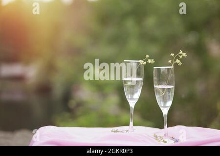 Bel automne. Champagne avec fleurs sauvages à l'extérieur. Pique-nique photo sur la nature avec lumière du soleil. Concept de célébration de la vie et de la solitude. Verres avec ch Banque D'Images