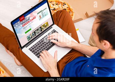 Homme avec ordinateur portable avec le site Web de la carte de résident permanent des États-Unis Banque D'Images