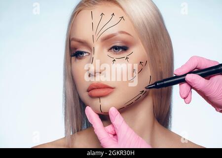 Belle femme blonde avec des marques pour la chirurgie plastique sur son visage Banque D'Images