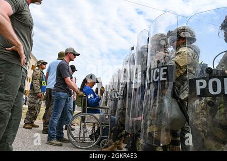 Les membres des forces de sécurité de la US Air Force portant des vêtements civils agissent comme manifestants dans un exercice de contrôle des foules qui mène à des arrestations simulées effectuées par les organismes civils d'application de la loi pendant la PATRIOT 21 le 17 juin 2021 à fort McCoy, Wisconsin. PATRIOT 21 est un exercice de formation conçu pour que les militaires travaillent aux côtés de la gestion civile des urgences et des premiers intervenants de la même manière qu'ils le feraient en cas de catastrophe naturelle, de sorte que dans le cas d'une catastrophe réelle, toutes les agences puissent maximiser leurs efforts d'intervention, fournir les ressources nécessaires aux collectivités touchées et économiser davantage Banque D'Images