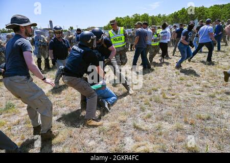 Les membres des forces de sécurité de la US Air Force portant des vêtements civils agissent comme manifestants dans un exercice de contrôle des foules qui mène à des arrestations simulées effectuées par les organismes civils d'application de la loi pendant la PATRIOT 21 le 17 juin 2021 à fort McCoy, Wisconsin. PATRIOT 21 est un exercice de formation conçu pour que les militaires travaillent aux côtés de la gestion civile des urgences et des premiers intervenants de la même manière qu'ils le feraient en cas de catastrophe naturelle, de sorte que dans le cas d'une catastrophe réelle, toutes les agences puissent maximiser leurs efforts d'intervention, fournir les ressources nécessaires aux collectivités touchées et économiser davantage Banque D'Images