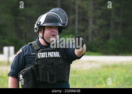 La police de l'État du Nebraska et du Wisconsin donne des instructions aux gardes nationaux lors d'un exercice de contrôle des foules simulé le 17 juin 2021, lors d'un PATRIOT 21 à fort McCoy, Wisconsin, où la Garde nationale a été activée pour aider les organismes locaux d'application de la loi dans leurs efforts de contrôle des foules. PATRIOT 21 est un exercice de formation conçu pour que les militaires travaillent aux côtés de la gestion civile des urgences et des premiers intervenants de la même manière qu'ils le feraient en cas de catastrophe naturelle, de sorte que dans le cas d'une catastrophe réelle, toutes les agences puissent maximiser leurs efforts d'intervention et fournir les ressources nécessaires Banque D'Images