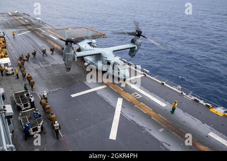 MER DES PHILIPPINES (17 juin 2021) les Marines affectés à la 31e unité expéditionnaire maritime (UMM) se préparent à embarquer un Osprey MV-22B sur le pont de vol du navire d'assaut amphibie déployé par l'avant USS America (LHA 6). L'Amérique, navire chef de file du America Amphiobie Ready Group, ainsi que le 31e MEU, opère dans la zone d'opérations de la 7e flotte des États-Unis pour améliorer l'interopérabilité avec les alliés et les partenaires et servir de force de réponse prête à l'emploi pour défendre la paix et la stabilité dans la région Indo-Pacifique. Banque D'Images