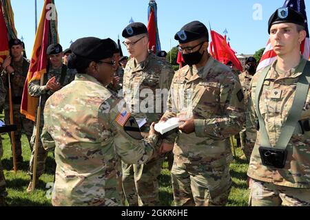 Sgt. Commandement Le major Henney Hodgkins, conseiller principal inscrit, 20e Commandement des explosifs nucléaires chimiques biologiques radiologiques (CBRNE), donne chacun à neuf soldats un livre différent sur le leadership, le 17 juin, lors de sa cérémonie de changement de responsabilité, tenue à Fanshaw Field, sur le terrain d'essai d'Aberdeen, Maryland. L’intention de Hodgkins n’était pas seulement d’enseigner le leadership aux soldats juniors, mais aussi à leurs dirigeants. Banque D'Images