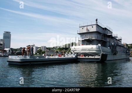 YOKOSUKA, Japon (18 juin 2021) Commandant, activités de la flotte Yokosuka (CFAY) opérations portuaires les équipes de bateaux soutiennent une évolution de l'arrimage à sec de l'atelier flottant YR 85 pour les réparations et l'entretien dans le quai sec no 2 de CFAY qui a été construit à l'origine en 1884. Une fois la barge en place, le quai sec a été drainé, ce qui donne aux travailleurs un accès complet à toutes les parties de la barge pour réparation. Depuis plus de 75 ans, la CFAY fournit, entretient et exploite des installations et des services de base à l'appui des forces navales déployées à l'avant de la 7e flotte américaine, des commandements de locataires et des milliers de personnes militaires et civiles Banque D'Images