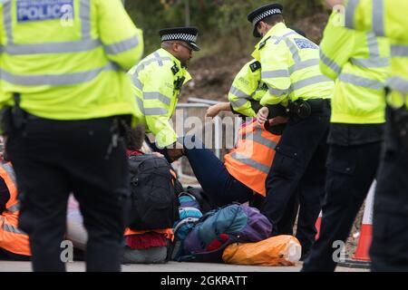 Enfield, Royaume-Uni. 15 septembre 2021. Les agents de la police métropolitaine arrêtent un activiste du climat d'Isolate Britain qui avait bloqué une voie de dérapage de la M25 à la sortie 25 dans le cadre d'une campagne destinée à pousser le gouvernement britannique à apporter des changements législatifs significatifs pour commencer à réduire les émissions. Les militants, qui ont écrit au Premier ministre Boris Johnson le 13 août, Exigent que le gouvernement promette immédiatement à la fois de financer et d'assurer l'isolation de tous les logements sociaux en Grande-Bretagne d'ici 2025 et de produire dans les quatre mois un plan national juridiquement contraignant pour financer et assurer le fu Banque D'Images