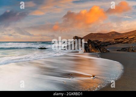 Vagues s'écrasant sur la plage de sable Playa de la Solapa au coucher du soleil, Fuerteventura, îles Canaries, Espagne, Atlantique, Europe Banque D'Images