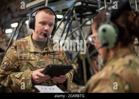 Sgt tech. Mark Goss, technicien en évacuation aéromédicale du 183e Escadron d'évacuation aéromédicale, parle avec un membre de l'équipage lors d'un exercice médical à bord d'un C-17 Globemaster III le 18 juin 2021. Le scénario de formation à bord était l'une des nombreuses missions de soins simulés effectuées au cours de la formation annuelle pour le 183e EI et d'autres membres de la 172e Escadre de transport aérien à Porto Rico. Les scénarios de formation, qui impliquent des équipages aéromédicaux et du personnel de soutien au sol à partir du 183e, aident à s'assurer que les aviateurs sont préparés pour des événements réels. Escadrons d'évacuation aéromédicale Banque D'Images