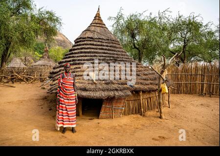 Jeunes femmes devant une cabane traditionnelle de la tribu Laarim, Boya Hills, Equatoria de l'est, Soudan du Sud, Afrique Banque D'Images