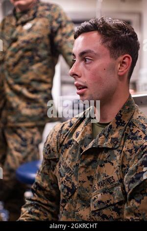 Caporal du corps des Marines des États-Unis Levi Smith, un maître-chien de travail militaire de la 31e unité expéditionnaire maritime (MEU), enseigne une classe de premiers secours K-9 à bord de l'USS Germantown (LSD-42) à Sasebo, au Japon, le 19 juin 2021. L'entraînement a été mené pour présenter l'occasion pour les marins de côté vert et bleu d'être équipés avec les connaissances sur la façon de traiter un militaire K-9. Le 31e MEU opère à bord de navires du America Amphiobie Ready Group dans la zone d'opérations de la 7e flotte pour améliorer l'interopérabilité avec les alliés et les partenaires et servir de force de réaction prête à défendre la paix et la stabilité dans Banque D'Images