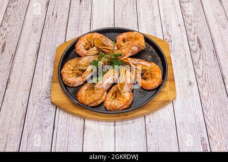 Crevettes grillées cuisinées dans leur propre jus, servies sur une plaque de métal chaude Banque D'Images