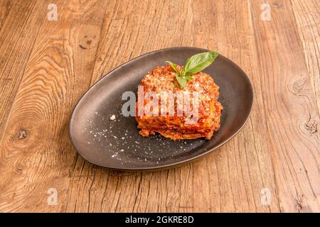 Lasagnes de boeuf avec beaucoup de viande et beaucoup de tomate avec fromage râpé et plusieurs feuilles de pâtes entre la viande, le tout recouvert de feuilles de basilic Banque D'Images