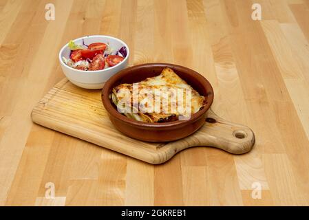 Grandes lasagnes au fromage avec des couches de pâtes, gratin de béchamel avec plus de fromage râpé et salade de tomates et de choux Banque D'Images