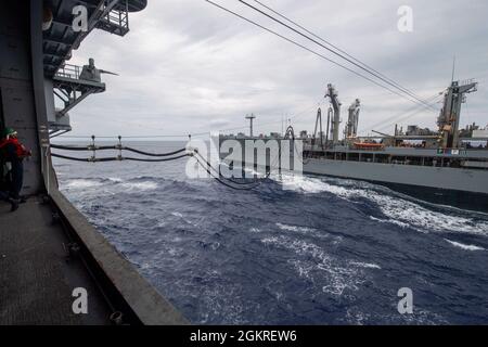 MER DES PHILIPPINES (21 juin 2021) Rappahannock USNS Rappahannock (T-AO 204) ravitailler le navire d'assaut amphibie déployé à l'avant USS America (LHA 6) lors d'un ravitaillement en mer. L'Amérique, navire chef de file du America Amphiobie Ready Group, ainsi que la 31e Marine Expeditionary Unit, opère dans la zone d'opérations de la 7e flotte des États-Unis pour améliorer l'interopérabilité avec les alliés et les partenaires et servir de force de réaction prête à l'emploi pour défendre la paix et la stabilité dans la région Indo-Pacifique. Banque D'Images