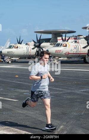 210621-N-DW158-1068 OCÉAN INDIEN (le 21 juin 2021) Spécialiste des communications de masse 2e classe Jason Tarleton, de Monticello, Géorgie, participe à une course de 5 km sur le pont de vol du seul porte-avions déployé par l'avant de la marine américaine USS Ronald Reagan (CVN 76). Ronald Reagan, le navire amiral du Carrier Strike Group 5, fournit une force prête au combat qui protège et défend les États-Unis, ainsi que les intérêts maritimes collectifs de ses alliés et partenaires dans la région Indo-Pacifique. Banque D'Images