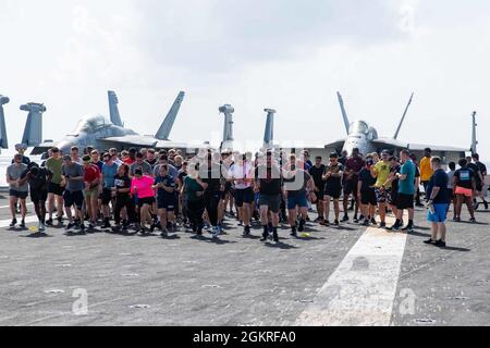 210621-N-DW158-1045 OCÉAN INDIEN (le 21 juin 2021) des marins participent à une course de 5 km sur le pont de vol du seul porte-avions déployé par l’avant de la Marine américaine, l’USS Ronald Reagan (CVN 76). Ronald Reagan, le navire amiral du Carrier Strike Group 5, fournit une force prête au combat qui protège et défend les États-Unis, ainsi que les intérêts maritimes collectifs de ses alliés et partenaires dans la région Indo-Pacifique. Banque D'Images