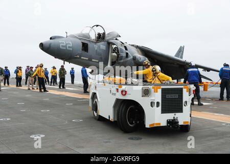 210621-N-YK910-1006 OCÉAN PACIFIQUE (21 juin 2021) – les marins s'exercent à déplacer un cadre d'Harrier AV-8B marin utilisé pour l'entraînement sur le pont de vol à bord du navire d'assaut amphibie USS Tripoli (LHA 7), juin 21. Tripoli mène actuellement des opérations de routine dans la troisième flotte des États-Unis. Banque D'Images
