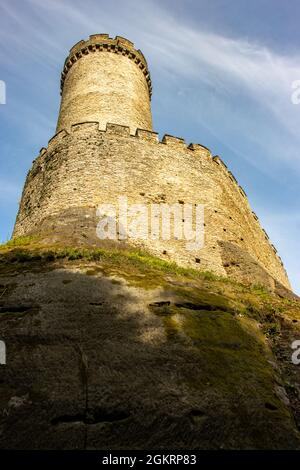 Tour circulaire en pierre derrière les murs avec les remparts d'un château gothique. Banque D'Images