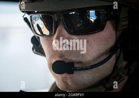 Une marine américaine avec reconnaissance de la force observe le navire d'assaut amphibie USS America (LHA 6) en route vers l'USS Germantown (LSD 42) pour effectuer un exercice d'entraînement d'opération d'interdiction maritime (MIO) en mer des Philippines, le 24 juin 2021. Le MIO consistait en des Marines de reconnaissance de la Force qui se sont rapidement déracinés vers l'USS Germantown et qui ont exécuté un scénario de perquisition et de saisie avec le soutien de l'équipe de débarquement du Bataillon 3/5 comme élément de sécurité. Le 31e MEU opère à bord de navires du America Amphiobie Ready Group dans la zone d'exploitation de la 7e flotte afin d'améliorer l'interopérabilité avec tous Banque D'Images