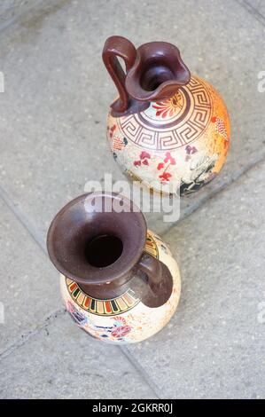 Vue verticale du dessus de deux vases grecs avec des dessins isolés sur le sol pavé Banque D'Images