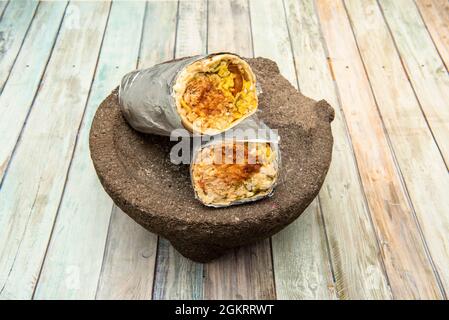 Burrito mâle avec sauce chipotle sur mortier en pierre naturelle sur table en bois Banque D'Images