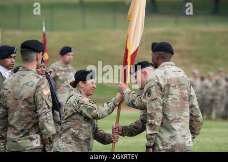 Sgt. Commandement Le Maj Jacqueline Becerra, conseillère principale inscrite à la 16e Brigade de soutien, passe les couleurs de l'unité au colonel Scott B. Kindberg, commandant sortant de la 16e Brigade de soutien, lors d'une cérémonie de changement de commandement au champ de Minick, Baumholder, Allemagne, le 23 juin 2021. Au cours de la cérémonie, Kindberg a officiellement abandonné le commandement du 16e SB au commandant entrant Col. Angel R. Estrada. Banque D'Images