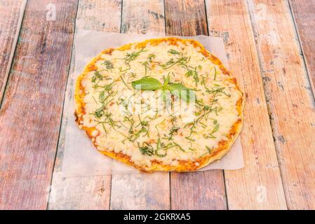 Pizza à Margarita avec beaucoup de mozzarella et beaucoup de basilic tranchés sur du papier blanc Banque D'Images