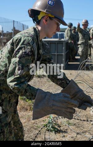 PORT HUENEME (Californie) (23 juin 2021) le constructeur Sara Harris met en place un câble en C autour d'une tente de bataillon dans le cadre de la pratique de défense périmétrique pendant l'exercice de poste de commandement (CPX) avec le bataillon de construction mobile de la Marine (NMCB) 18. CPX est une évolution de formation menée par les bataillons de Seabee pour évaluer leur exercice de préparation à la mission afin de préparer les bataillons aux opérations futures. NMCB 18 les Seabees sont les experts en génie expéditionnaire et en construction du service naval en fournissant des forces d'ingénierie et de construction sur mesure, adaptables et prêtes au combat qui se déploient pour soutenir la Marine o Banque D'Images