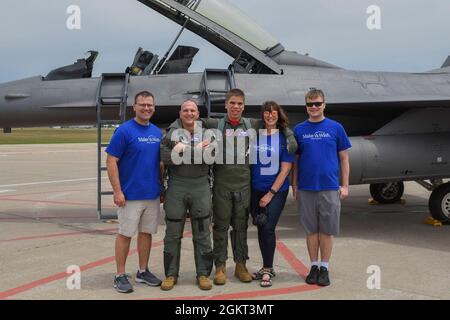 Le lieutenant-colonel Mark Noble de la Garde nationale aérienne des États-Unis, 114e inspecteur général de l'escadre de chasse, et Noah Lamfers, participant à Make-a-Wish, posent pour une photo de groupe avec la famille Lamfers à Joe Foss Field, Dakota du Sud, le 24 juin 2021. Make-A-Wish South Dakota & Montana coordonné avec la 114e aile Fighter pour rendre le souhait des Lamfers de monter dans un F-16 plus vrai. Banque D'Images