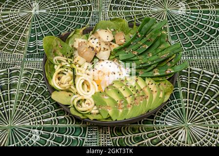 Salade verte avec nouilles courgettes, œuf poché, haricots verts, pomme de terre, épinards et avocat Banque D'Images