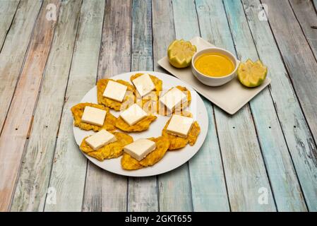 Assiette avec patacones plantain et fromage frais et sauce Chili pour trempette Banque D'Images