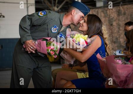 Le colonel Joshua Wood, commandant entrant de la 51e Escadre de chasseurs, présente des fleurs à son épouse lors de la 51e cérémonie de passation de commandement à la base aérienne d'Osan, République de Corée, le 25 juin 2021. Il est d'usage de présenter aux familles des officiers entrants et sortants des marques d'appréciation pour le soutien du commandant alors qu'ils s'acquittent de leurs responsabilités de leadership. Banque D'Images