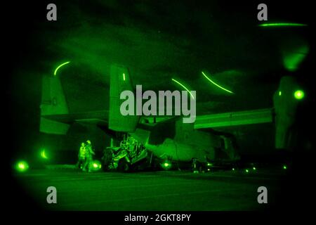 MER DE CHINE ORIENTALE (26 juin 2021) les Marines affectées à la 31e unité expéditionnaire maritime (MEU) chargent un véhicule de reconnaissance sur un MV-22B Osprey lors d'un exercice de raid de nuit sur le pont de vol du navire d'assaut amphibie USS America déployé à l'avant (LHA 6). L'Amérique, navire chef de file du America Amphiobie Ready Group, ainsi que le 31e MEU, opère dans la zone d'opérations de la 7e flotte des États-Unis pour améliorer l'interopérabilité avec les alliés et les partenaires et servir de force de réponse prête à l'emploi pour défendre la paix et la stabilité dans la région Indo-Pacifique. Banque D'Images