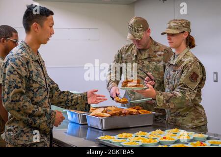 Le Sergent d’état-major Elizabeth Pettek et le Sergent-maître principal David Hill, tous deux membres du 152e Escadron de soutien de la Force, Garde nationale aérienne du Nevada, servent un déjeuner à Marines avec le 6e Bataillon des communications, Réserve des Forces maritimes, Brooklyn, New York, Pendant le Camp Paumalau IRT 2021 au Centre d’excellence STEM des éclaireuses d’Hawaï au Camp Paumalau, Hawaii, le 28 juin 2021. Les escadrons du génie civil de l'IRT construisent de nouveaux chalets, démolissent d'anciennes structures et embellissent le Camp Paumalau de mai à août 2021, et les escadrons de soutien de la Force rotative serviront trois repas par jour pour le Banque D'Images