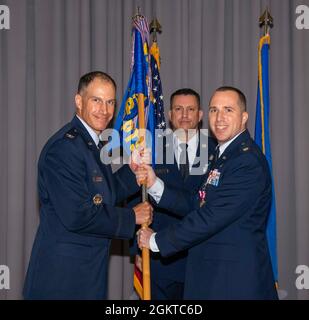 Le Maj. Kevin Byram, à droite, commandant sortant du 436e Escadron de contrôle, transmet le guide au colonel Matt Husemann, à gauche, commandant de la 436e Escadre de transport aérien, lors d'une cérémonie de changement de commandement à la base aérienne de Douvres, Delaware, le 28 juin 2021. La cérémonie a vu Byram renoncer au commandement du lieutenant colonel Gretchen Lewis. Banque D'Images