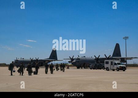 Un groupe d'aviateurs de la 55e Electronic combat Group Walk en direction de deux US Air Force EC-130H Compass appelle sur la ligne de vol lors d'un exercice de préparation de démonstration de force à la base aérienne Davis-Monthan, Arizona, le 28 juin 2021. Le 55e ECG a exécuté cet exercice en utilisant sept EC-130H qui ont taxé, pris le pas et effectué des sorties de combat simulées. Banque D'Images