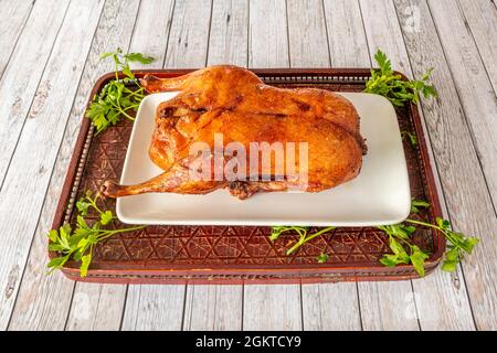 Canard entier cuit dans un style laqué chinois sur un panneau de bois servi dans un restaurant asiatique en Europe Banque D'Images