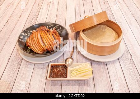 Recette chinoise typique de canard de Pékin rôti haché avec oignon haché, sauce et tortillas sur une assiette blanche Banque D'Images