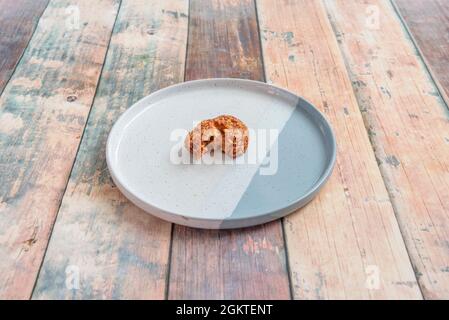 Croquette farcie de poivre caramélisé pour que l'intérieur soit visible sur une assiette bleue Banque D'Images