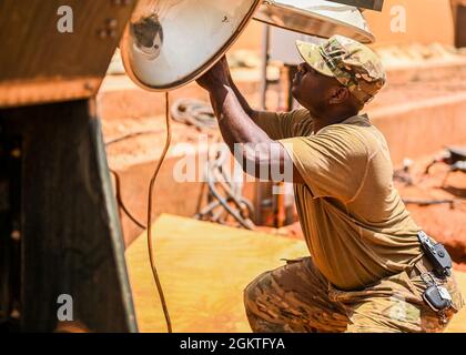 Tech. Sgt. Aundrey Esmie, 768e Escadron de la base aérienne expéditionnaire la production d'électricité du génie civil analyse une lumière brisée, le 27 juin 2021, à la base aérienne 101, au Niger. Ces experts utilisent un vaste éventail de compétences et de connaissances pour tout faire, du démarrage de générateurs portables à l'entretien et à l'exploitation de centrales électriques pour maintenir toutes nos bases en fonctionnement à pleine capacité. Banque D'Images