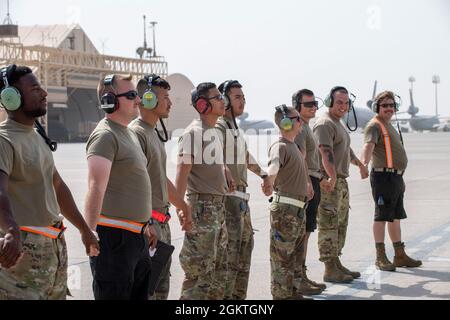 Les aviateurs de la US Air Force du 380e Escadron de maintenance d'aéronefs expéditionnaires, base aérienne Al Dhafra, Émirats arabes Unis, se joignent à eux dans le cadre de leur tradition de pré-lancement pour préparer l'avion EC-130H Compass Call à prendre son décollage le 29 juin 2021. Les membres qui soutiennent actuellement la mission Compass Call de l'ADAB sont déployés en tant qu'équipe de la base aérienne de Davis-Monthan, à Tucson, en Arizona, ce qui signifie qu'ils travaillent le même horaire pendant la durée de leur déploiement, ce qui favorise le moral et la camaraderie, et optimise l'efficacité de l'équipe. Banque D'Images